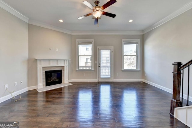 unfurnished living room featuring wood finished floors, a high end fireplace, stairway, crown molding, and ceiling fan