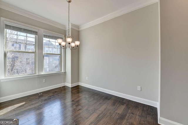 spare room featuring a notable chandelier, dark wood-type flooring, baseboards, and ornamental molding