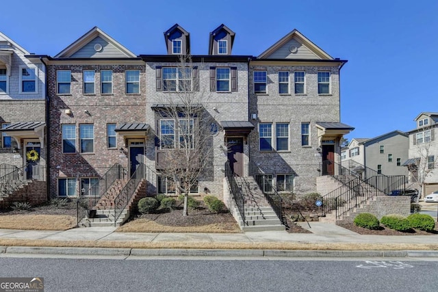 townhome / multi-family property featuring brick siding and stairway