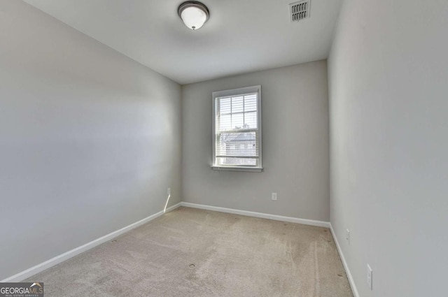 carpeted spare room featuring visible vents and baseboards