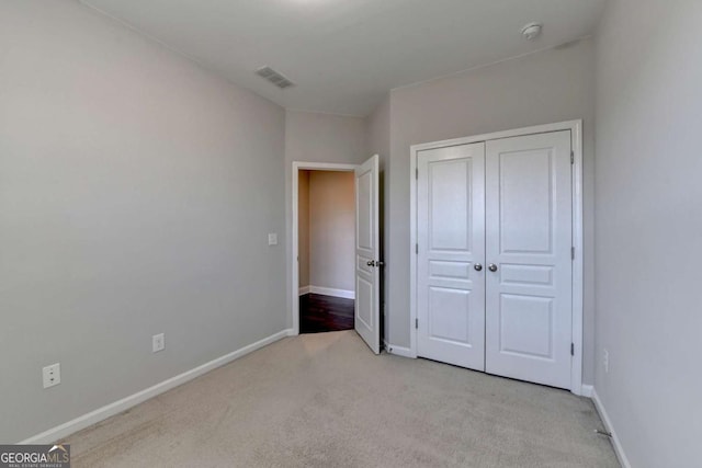 unfurnished bedroom featuring a closet, visible vents, carpet flooring, and baseboards