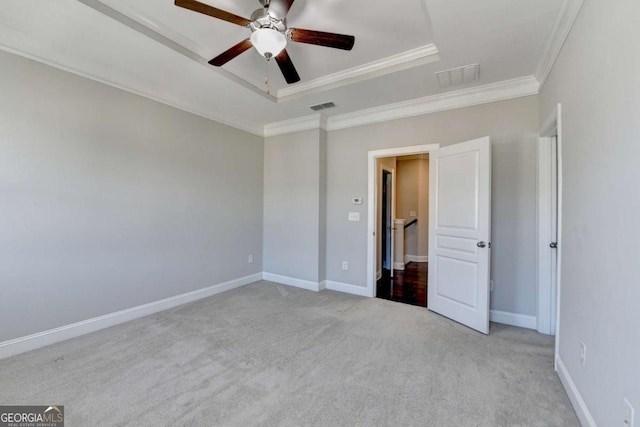 unfurnished bedroom featuring a tray ceiling, crown molding, visible vents, and light carpet