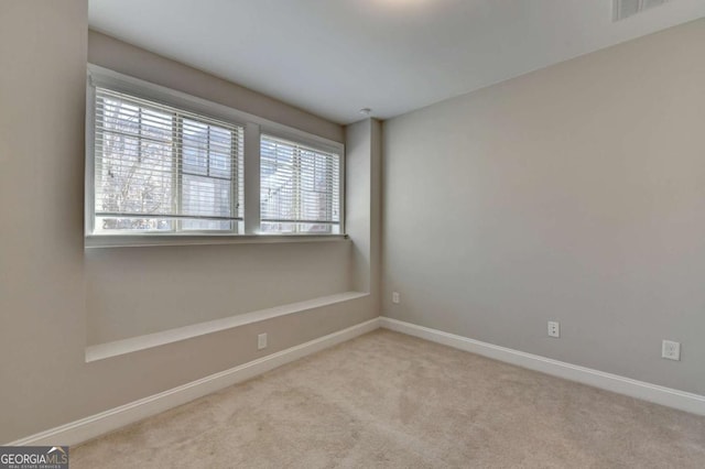 spare room with visible vents, baseboards, and carpet flooring