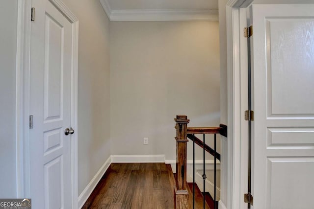 hall with crown molding, dark wood-style floors, an upstairs landing, and baseboards