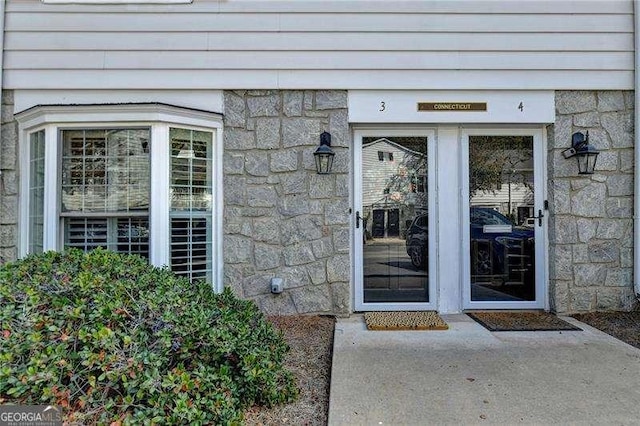 view of exterior entry featuring stone siding