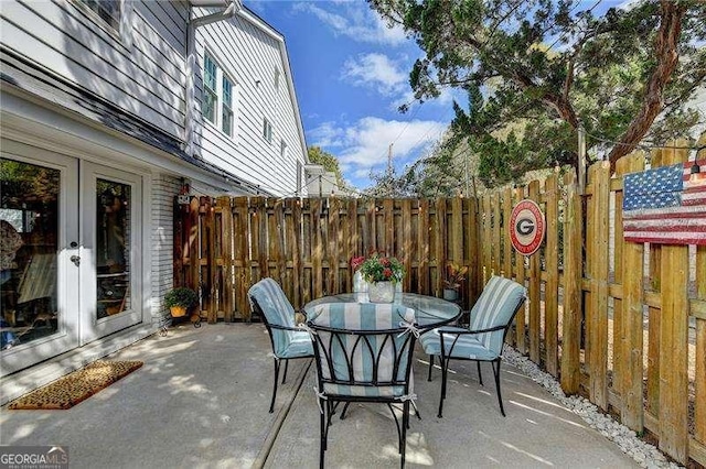 view of patio / terrace with french doors, outdoor dining area, and fence