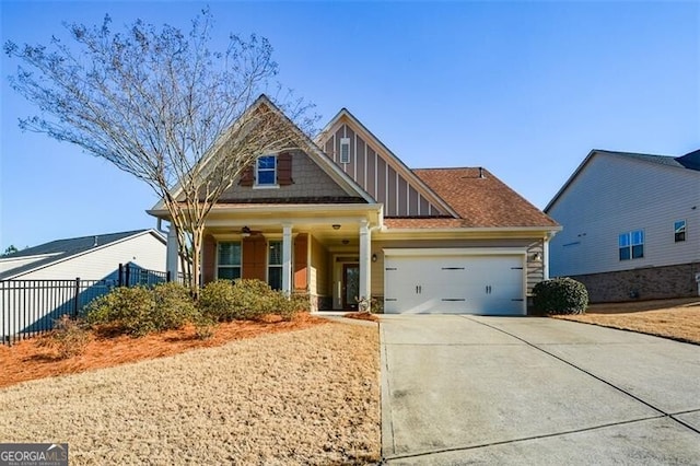 craftsman-style home featuring a garage, concrete driveway, and fence