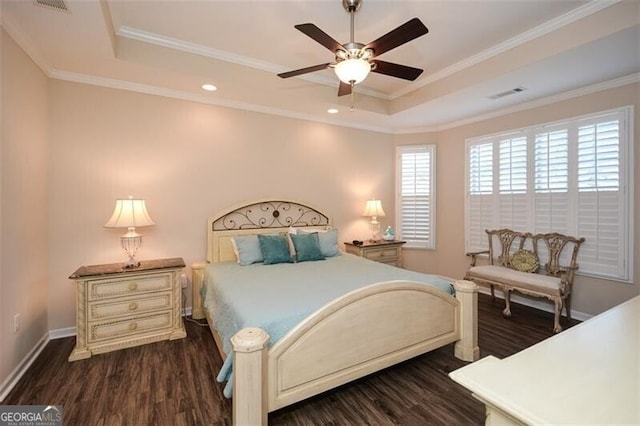 bedroom featuring dark wood finished floors, a tray ceiling, visible vents, and ornamental molding