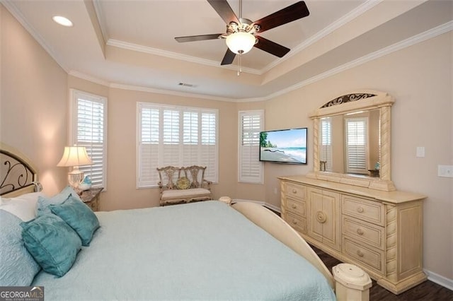 bedroom with visible vents, crown molding, a raised ceiling, and ceiling fan