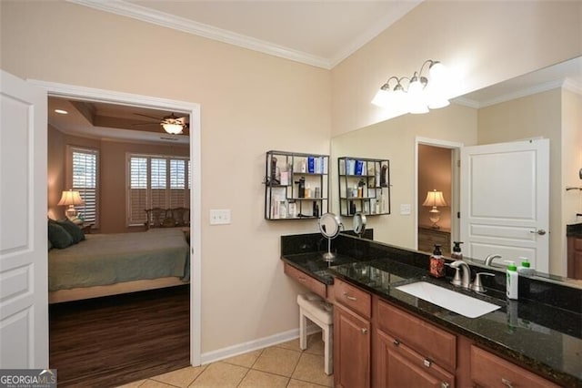 bathroom with tile patterned flooring, crown molding, baseboards, ensuite bath, and vanity