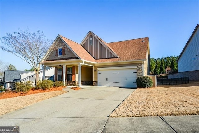 craftsman house featuring concrete driveway, a garage, fence, and stone siding