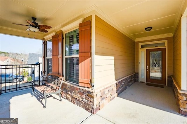 property entrance featuring a ceiling fan, covered porch, and stone siding