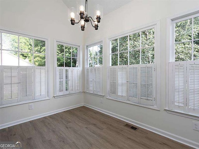 unfurnished sunroom with visible vents, a notable chandelier, and a healthy amount of sunlight