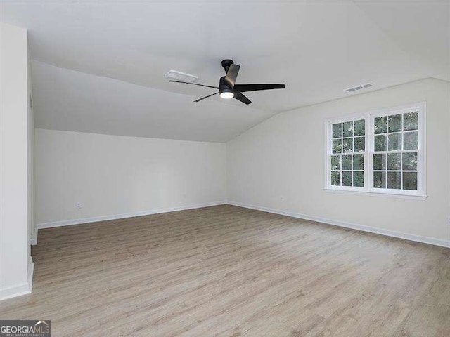 additional living space featuring visible vents, lofted ceiling, a ceiling fan, and wood finished floors