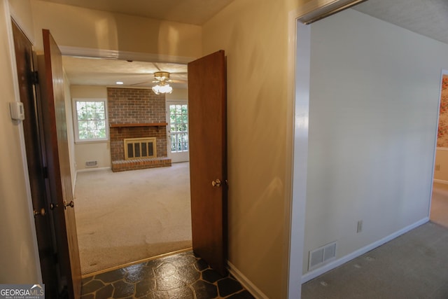 hall featuring carpet, visible vents, and baseboards