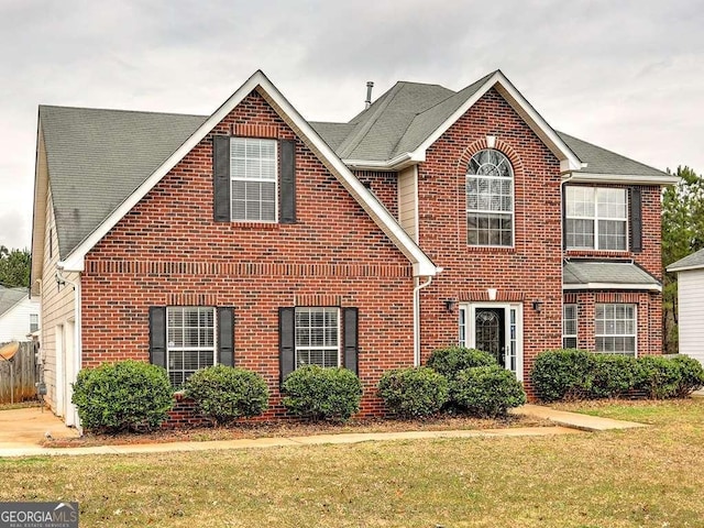 traditional-style house with a front yard and brick siding