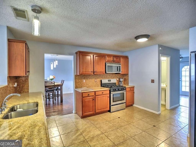 kitchen with a sink, stainless steel appliances, visible vents, and light countertops