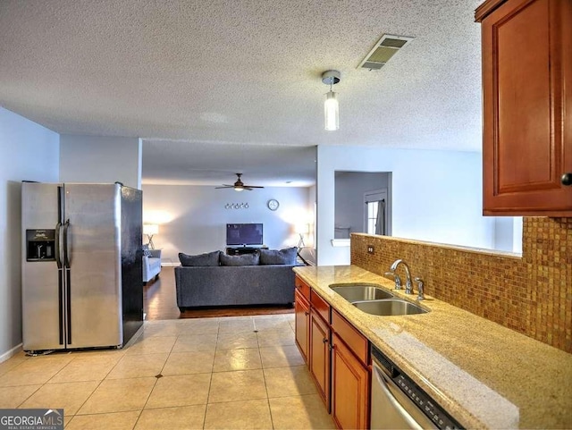 kitchen with a ceiling fan, visible vents, a sink, stainless steel appliances, and backsplash