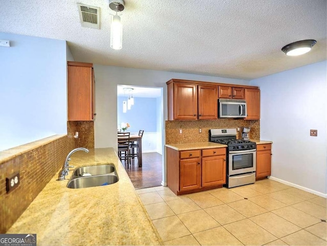 kitchen featuring a sink, visible vents, appliances with stainless steel finishes, and light countertops