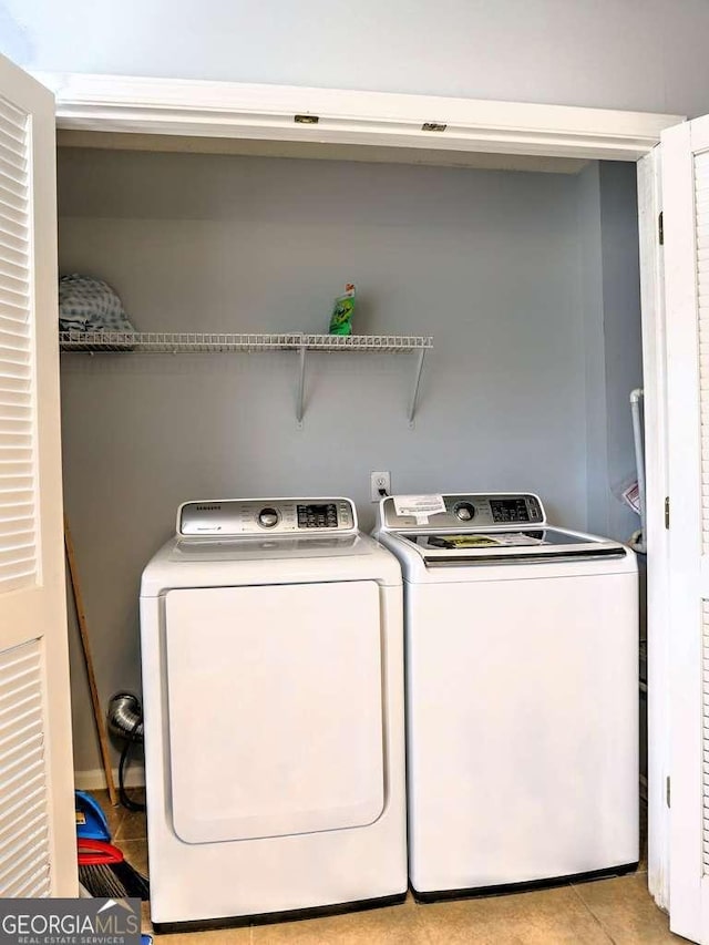 laundry room featuring laundry area, light tile patterned floors, and washing machine and dryer