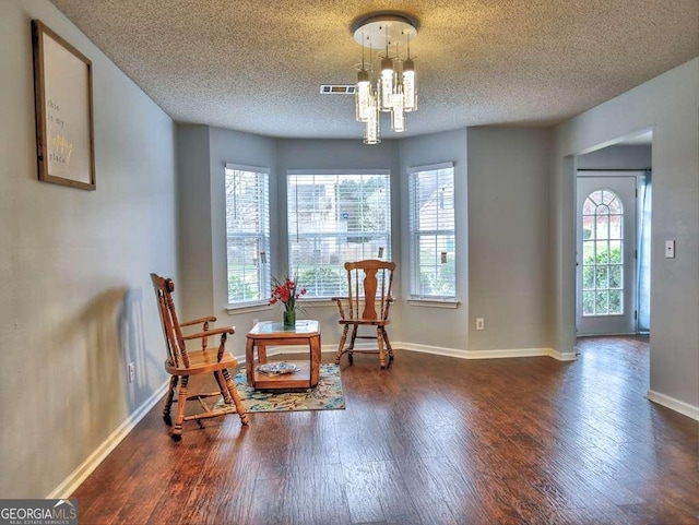 sitting room featuring visible vents, baseboards, a chandelier, a textured ceiling, and wood-type flooring