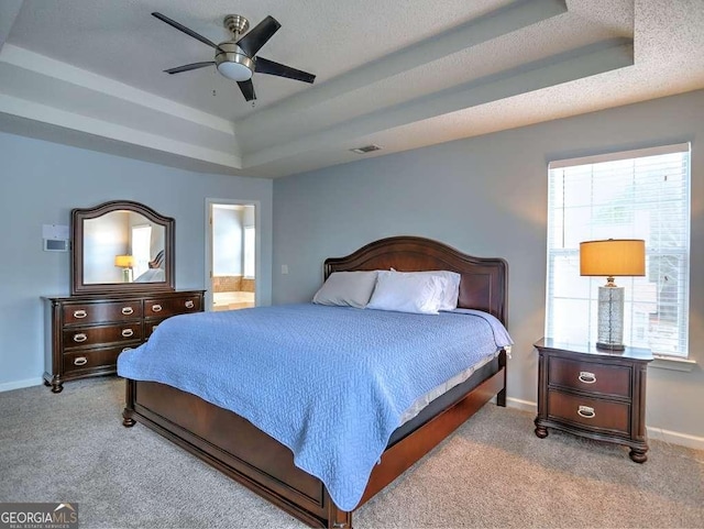 bedroom featuring a tray ceiling, carpet, visible vents, and baseboards