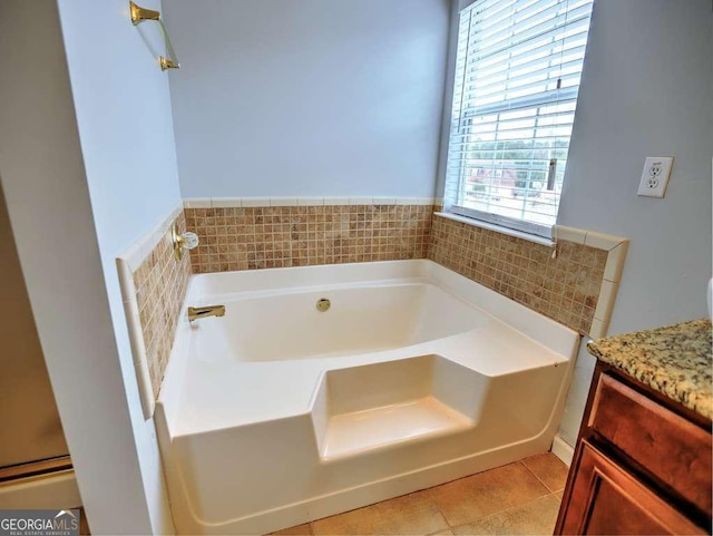 bathroom with a bath, vanity, and tile patterned flooring