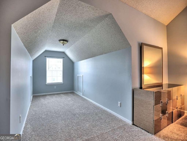 bonus room with baseboards, a textured ceiling, lofted ceiling, and carpet floors