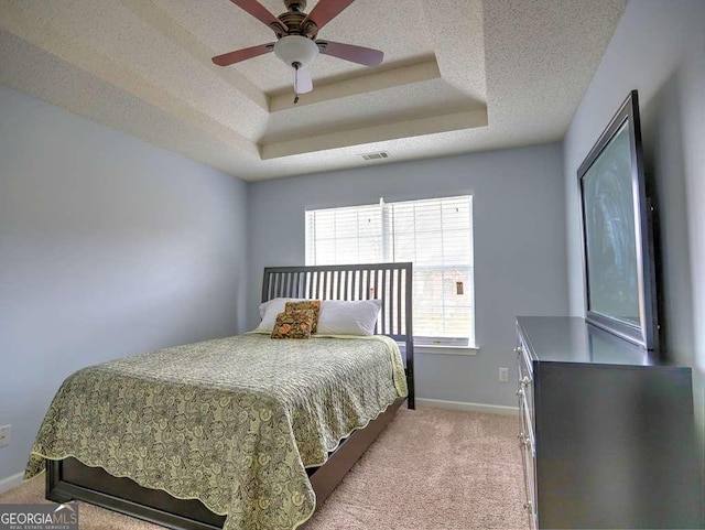 bedroom featuring visible vents, a raised ceiling, a textured ceiling, carpet floors, and baseboards