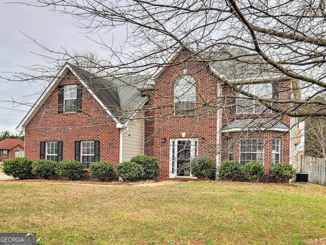 traditional home with a front yard, cooling unit, and brick siding