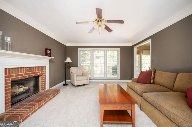 carpeted living area featuring ceiling fan, baseboards, a brick fireplace, and ornamental molding