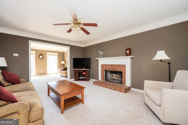 living room featuring baseboards, a fireplace, ceiling fan, crown molding, and light colored carpet