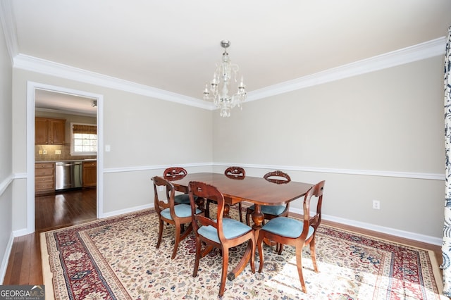 dining room featuring baseboards, an inviting chandelier, crown molding, and hardwood / wood-style flooring