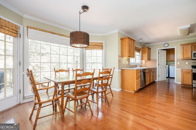 dining area with crown molding and light wood-style floors