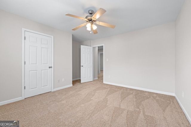 unfurnished bedroom featuring carpet, baseboards, and ceiling fan