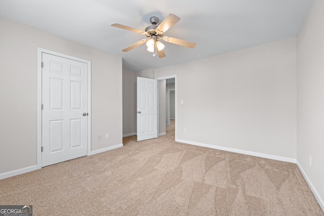 unfurnished bedroom with baseboards, carpet floors, and a ceiling fan