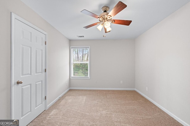unfurnished bedroom featuring light carpet, visible vents, ceiling fan, and baseboards