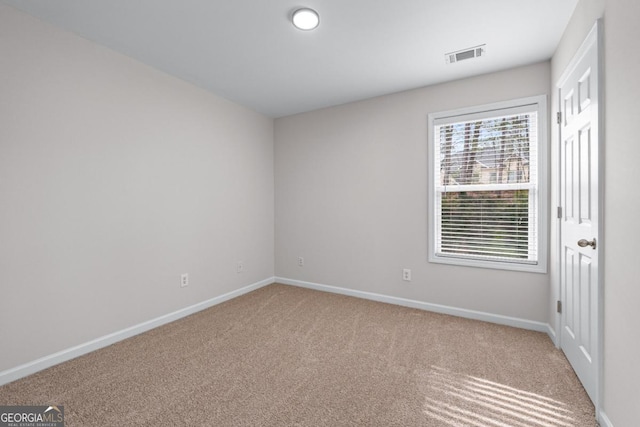 spare room with visible vents, carpet flooring, and baseboards