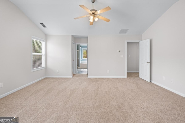 unfurnished bedroom featuring lofted ceiling, light colored carpet, visible vents, and baseboards