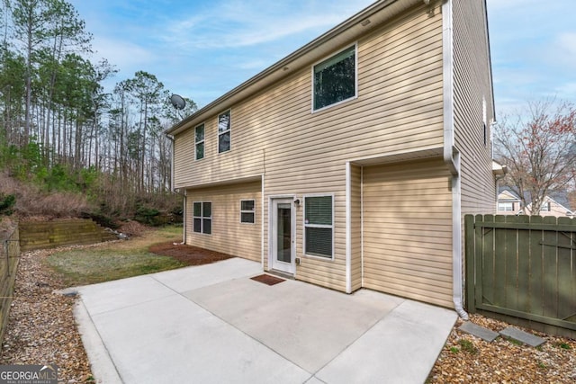 rear view of house featuring a patio and fence