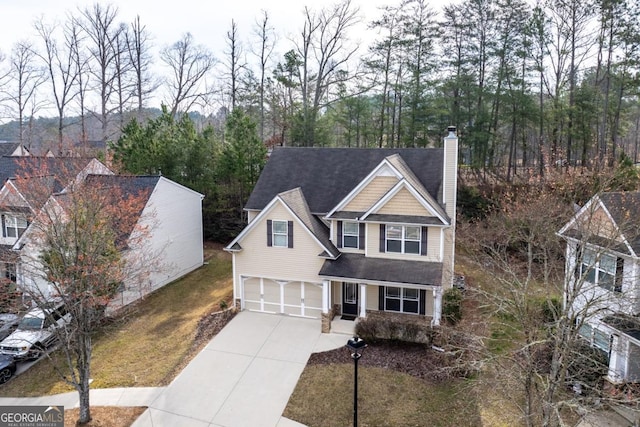 view of front of house with a garage, concrete driveway, and a chimney