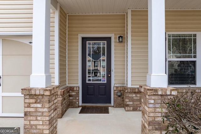 view of exterior entry with a porch and stone siding