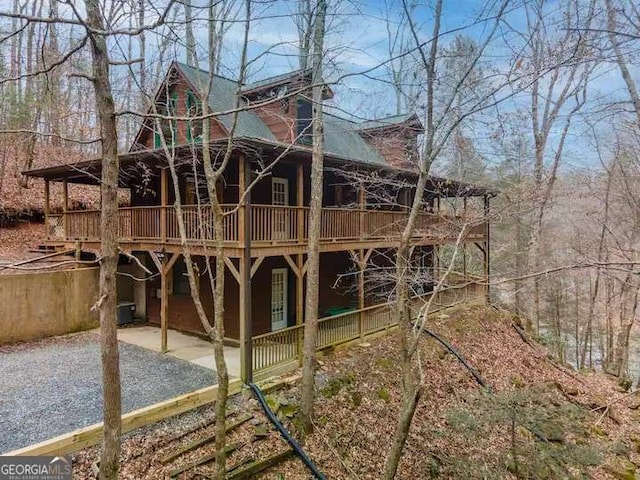 exterior space with a wooden deck, a patio, and gravel driveway