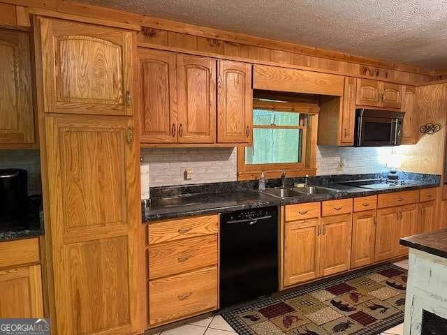 kitchen featuring a sink, electric stovetop, a textured ceiling, dishwasher, and dark countertops