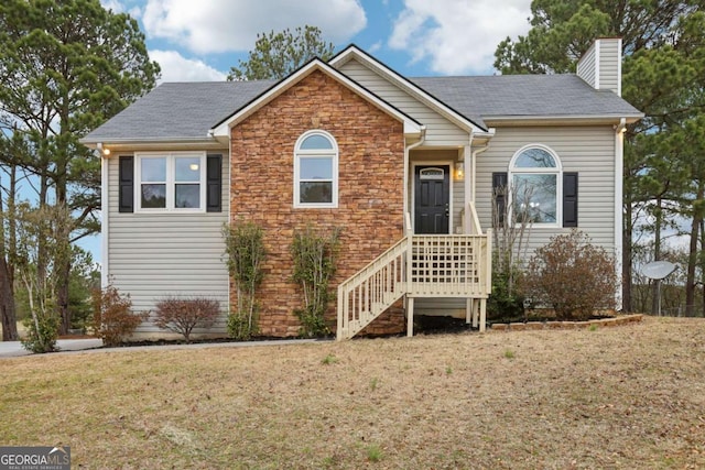 single story home with a front yard, stone siding, and a chimney