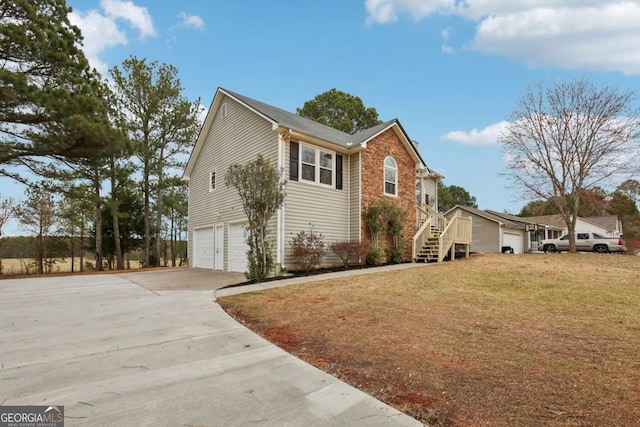 view of home's exterior featuring concrete driveway, stairway, a yard, and a garage