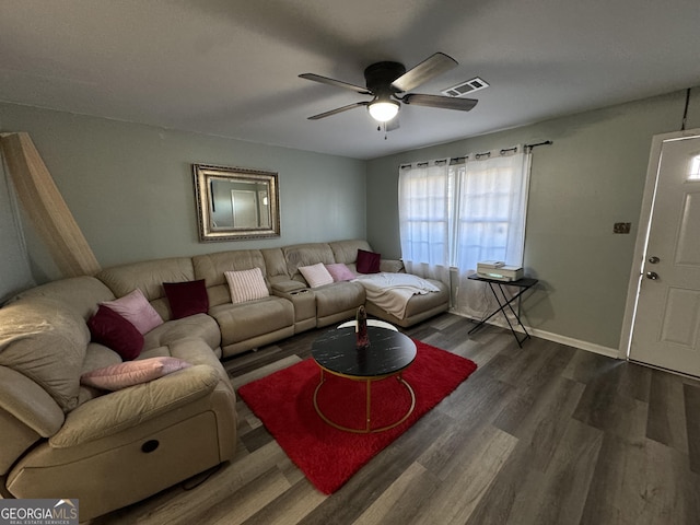 living room with baseboards, wood finished floors, visible vents, and ceiling fan