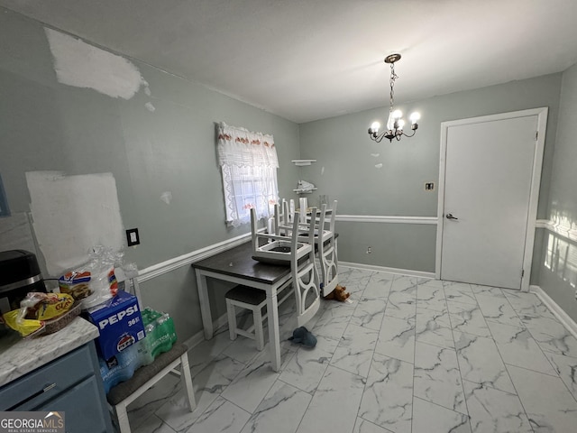 dining room with a chandelier, marble finish floor, and baseboards