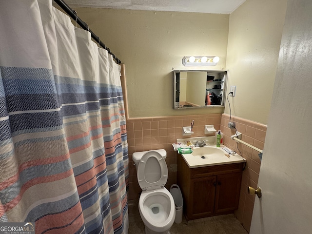 full bath with vanity, wainscoting, curtained shower, tile walls, and toilet