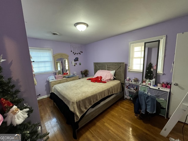 bedroom featuring visible vents, baseboards, and wood finished floors